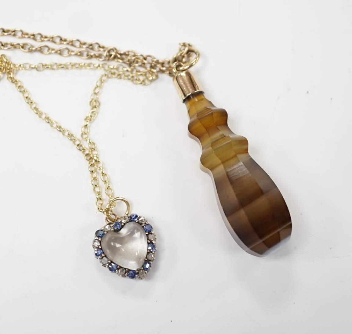 An early 20th century yellow metal, moonstone, sapphire and rose cut diamond set heart shaped pendant, 12mm on a yellow metal chain, together with a yellow metal mounted banded agate pendant, on a 9c chain. Fair conditio